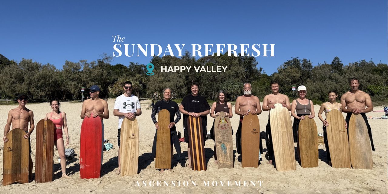 The Sunday Refresh group standing on the sand at Happy Valley holding wooden bellyboards